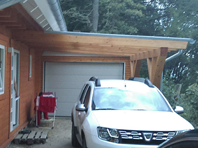 Einzelgarage mit Vorstand aus Holz. Carport und Garage in nachhaltiger Holzbbauweise, modernes Design und dennoch höchste Isolierung. Auf dem Foto sieht man eine Einzelgarage von M.S. Garagenbau GmbH mit Carport aus Holz. Nachhaltiger Holzcarport mit integrierter Iso-Garage.