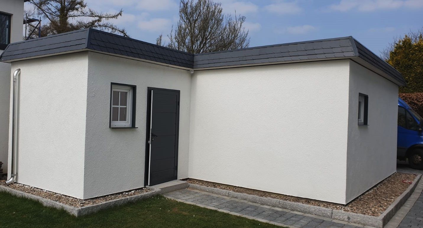 Foto eines Kellerersatzraums mit Tür und Fenster. Anbau an Garage mit Flachdach. Ausgeführt von MS Garagenbau GmbH