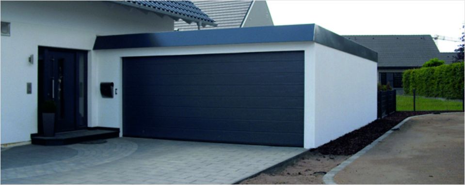 Foto einer Dopplegarage mit einfachem Sektioinator und Flachdach. Angefertigt von der MS Garagenbau GmbH