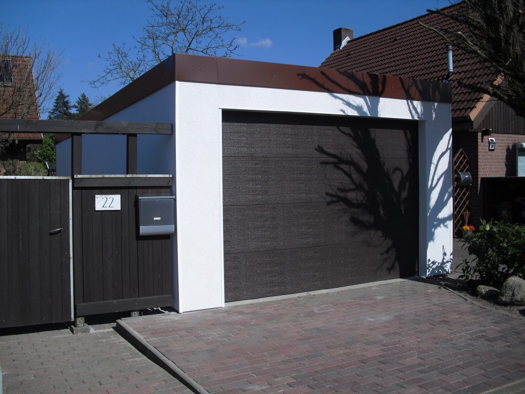 Individuelle Einzelgarage nach Maß für optimale Funktionalität und Sicherheit. Modernes Design nach individuellen Vorstellungen an eine Garage. Man sieht hier eine moderne Einzelgarage, die individuell an die Architektur des Hauses angepasst wurde und eine Einheit mit dem Eingangstor bildet.
