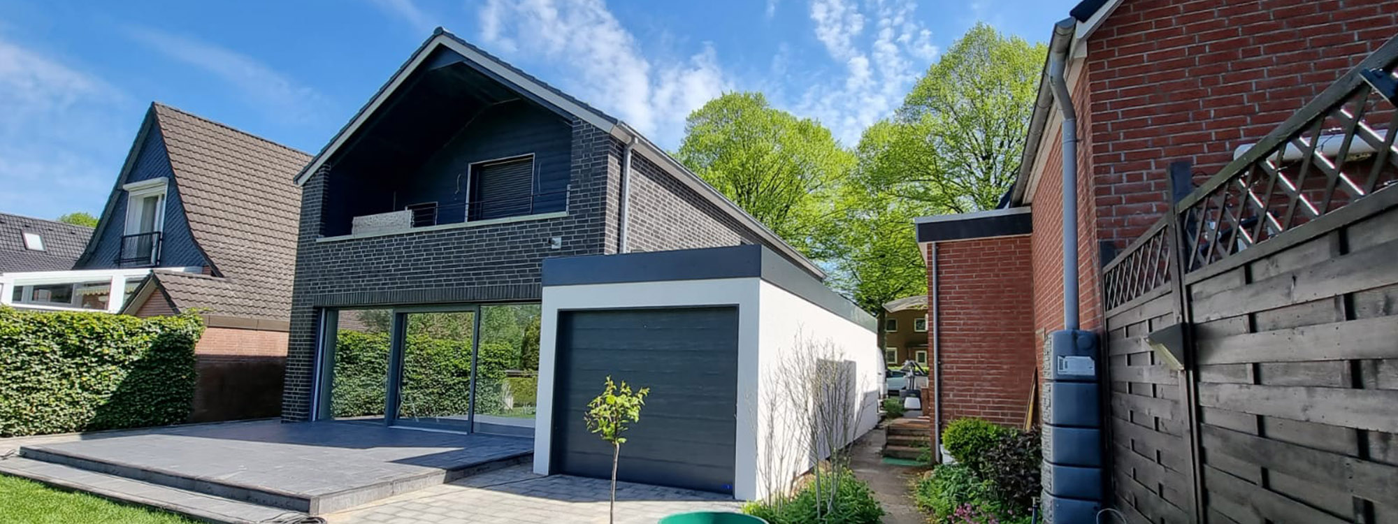 Eine individuell angefertigte isolierte Einzelgarage von M.S. Garagenbau GmbH ist auf dem Bild zu sehen, wie sie neben einem Einfamilienhaus steht. Die individuelle Einzelgarage wurde architektonisch auf das Design des Hauses angepasst und nach den Wünschen der Familie gebaut.