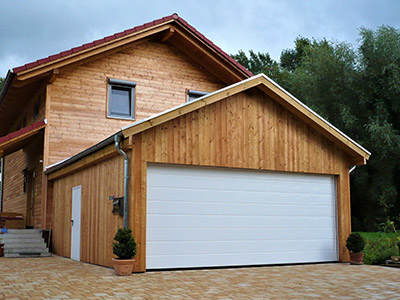 Die M.S. Garagenbau GmbH baut auch nachhaltige Garagen aus Holz, wie sie dieses Foto zeigt. Passend zum anliegenden Holzhaus wurde die Doppelgarage aus Holz gebaut und ist dennoch hervorragend isoliert. 